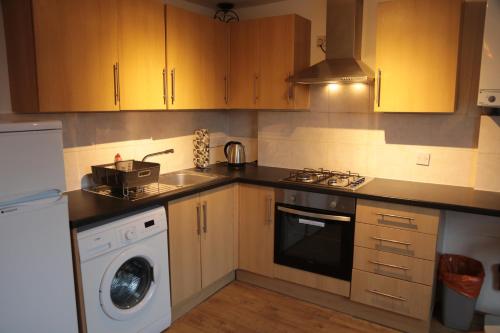 una cucina con lavandino e lavatrice di Kings Cross Apartments a Londra