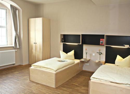 1 dormitorio con 2 camas y escritorio. en Augustinerkloster Gotha Herberge gGmbH, en Gotha