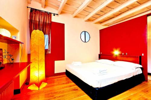 a bedroom with a large bed with red walls at delCINQUE 26 - Loft in Trastevere in Rome