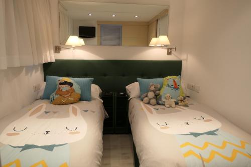 1 dormitorio con 2 camas con animales de peluche en Mirador De Begur, en Begur