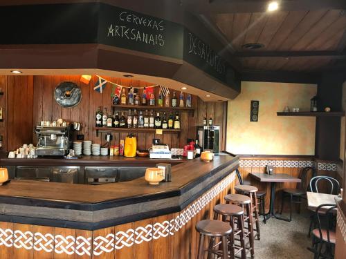 a bar in a restaurant with stools at a counter at Hotel Celta Galaico in Viveiro