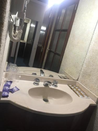 un baño con aseo y espejo en el Hotel Coliseo de Villa Gesell