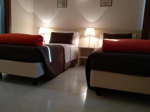 a hotel room with two beds and two chairs at B&B la Maison in Sammichele di Bari