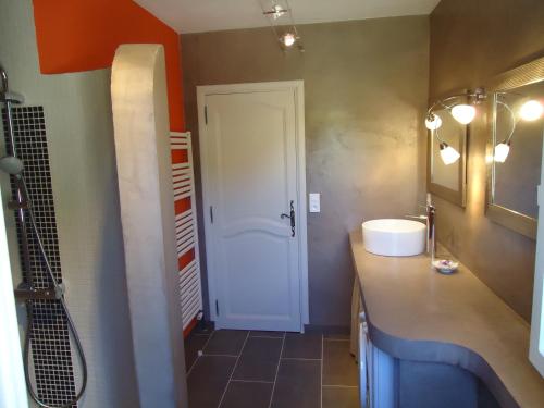 a bathroom with a sink and a white door at le petit coin de Noah in Châteauneuf-Val-Saint-Donat