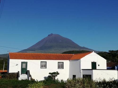 a white house with a mountain in the background at Casa dos biscoitos in Madalena