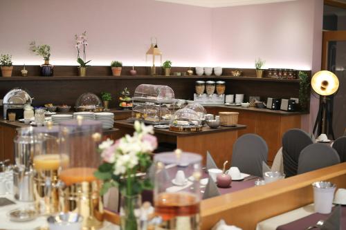 a dining room with tables and chairs with flowers on them at Boutique Hotel Beckenlehner in Unterhaching