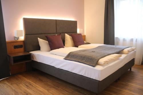 a bedroom with a large bed with a large headboard at Boutique Hotel Beckenlehner in Unterhaching