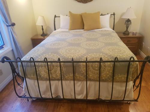 a bed in a bedroom with a wrought iron bed frame at Lady MacDonald Country Inn in Canmore