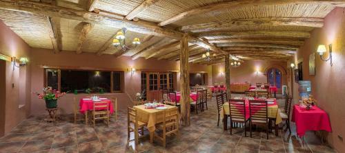 un restaurant avec des tables, des chaises et des nappes rouges dans l'établissement Hotel Casa Don Esteban, à San Pedro de Atacama