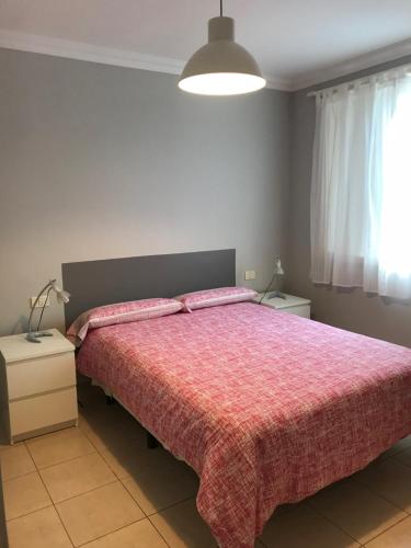 プエルト・デ・ラ・クルスにあるCerca de Playa Jardínのベッドルーム1室(ピンクの毛布付きの大型ベッド1台付)