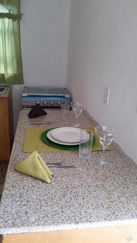 a table with a plate and glasses on a counter at Bahamas Petapat suite in Nassau