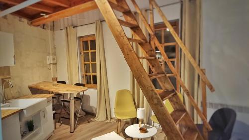 une chambre avec une échelle en bois dans une cuisine avec une table dans l'établissement Place de la Roquette, centre historique, à Arles
