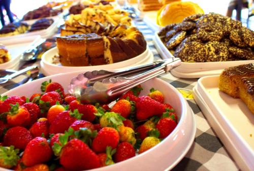 una tavola ricoperta di ciotole di fragole e dolci di Pousada Akonxego a Olímpia