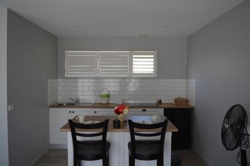 a kitchen with two chairs and a table with flowers on it at Harrison Grove in Forcett