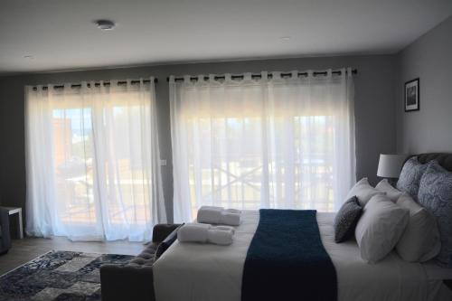 a bedroom with a bed and a couch and windows at Harrison Grove in Forcett