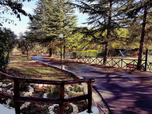 ein Park mit einer Bank, Bäumen und einem Zaun in der Unterkunft Citrigni in Peschici