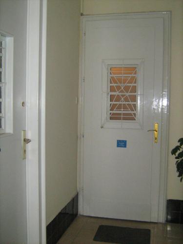 a white door with a window in a hallway at Apartment Dunja NS in Novi Sad