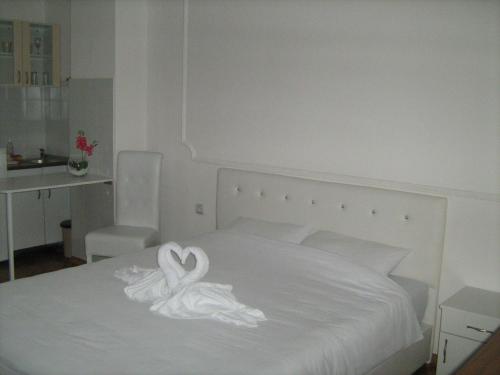 a white bed with a swan decoration on it at Apartment Dunja NS in Novi Sad