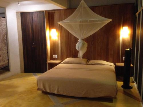 a bedroom with a bed with a net on it at Villa Luna de Miel in Mazunte