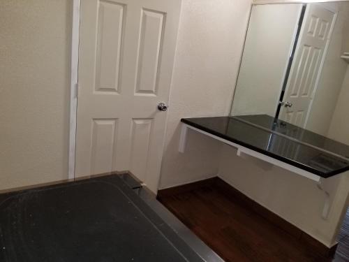a room with a door and a counter and a mirror at Buckboard Motel in Santa Maria