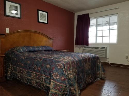 a bedroom with a bed and a window at Buckboard Motel in Santa Maria