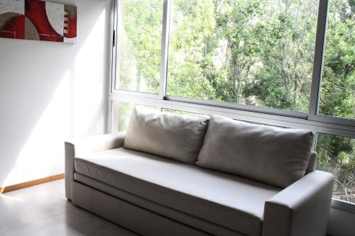 un sofá blanco sentado frente a una ventana en Apartamento Ana del Mar, en Las Gaviotas