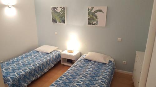 Zimmer mit 2 Betten und einer Lampe in der Unterkunft Apartamento Vista Mar e Piscina in Funchal
