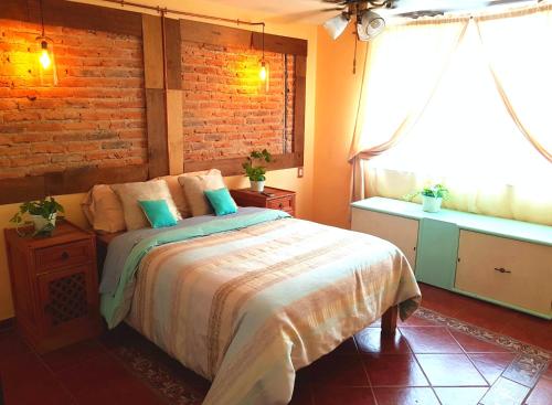 a bedroom with a bed and a brick wall at Casa Bonita in Guadalajara