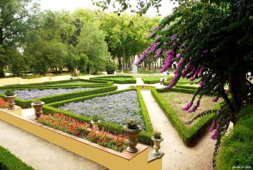 a garden with purple and purple flowers and a fountain at Mafra Guest House in Mafra