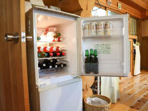 an open refrigerator filled with lots of drinks at Canadian Loghouse Inn AzuminoYujin in Azumino