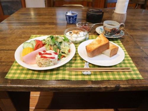 a table with two plates of food on a table at Canadian Loghouse Inn AzuminoYujin in Azumino