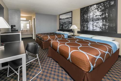 a hotel room with two beds and a desk at Super 8 by Wyndham Arlington Near AT&T Stadium in Arlington