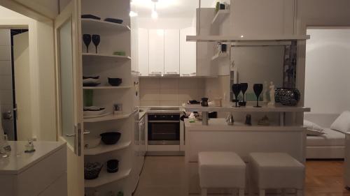 una cocina con paredes blancas y estanterías blancas en Apartman -stan u centru, en Trebinje
