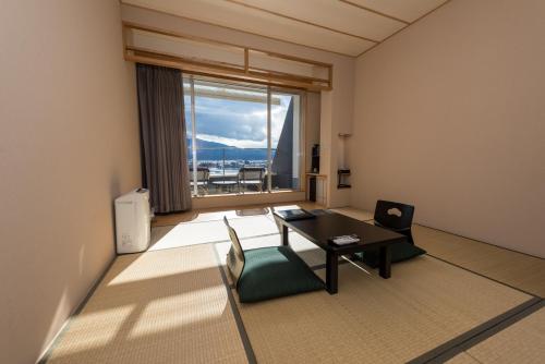 a room with a table and chairs and a large window at Mizno Hotel in Fujikawaguchiko