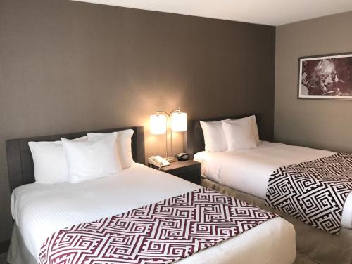 two beds in a hotel room next to each other at Best Western Colonel Butler Inn in Niagara on the Lake