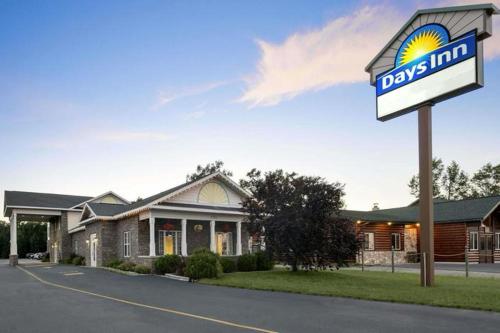 a days inn sign in front of a building at Days Inn by Wyndham Grayling in Grayling