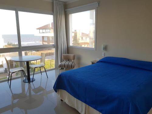 1 dormitorio con 1 cama azul, mesa y sillas en MitreCity en Ostende