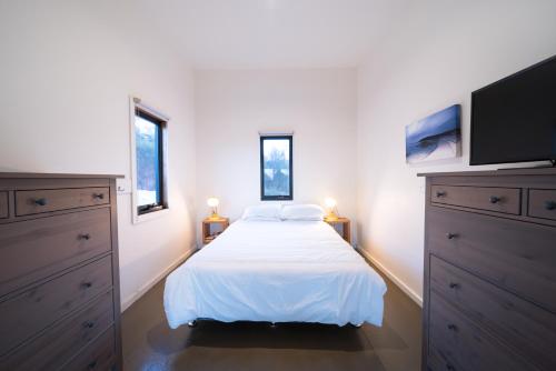 a bedroom with a bed and a flat screen tv at Sawyers Bay Shacks in Emita