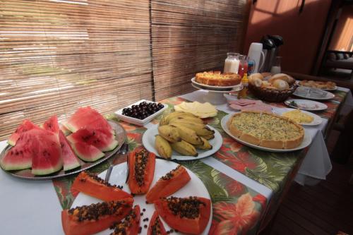 ein Tisch mit vielen Tellern voller Essen in der Unterkunft Itaoca Pousada in Itacaré
