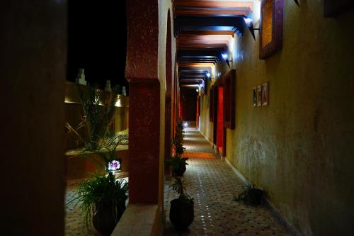 an alley way with potted plants in a building at Kasbah Hotel Ziz Palace Rissani in Rissani