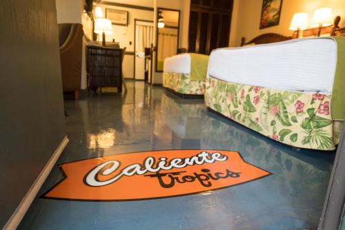 a room with two beds and a sign on the floor at Caliente Tropics in Palm Springs