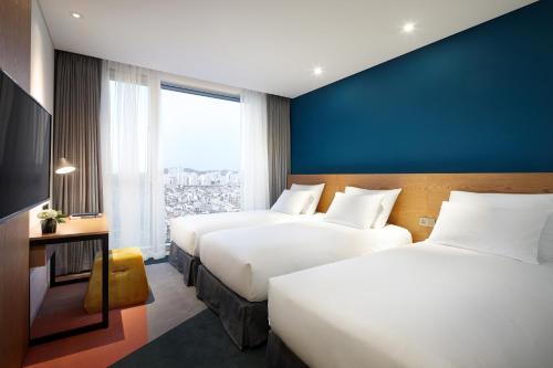 מיטה או מיטות בחדר ב-L7 Hongdae