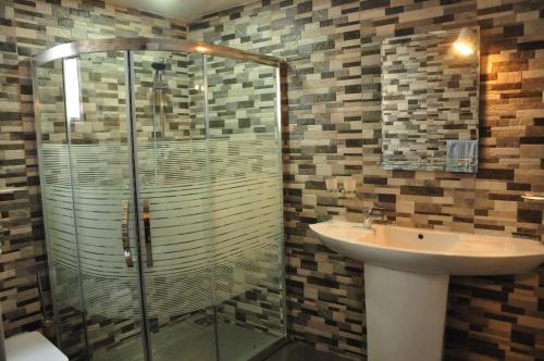 a bathroom with a glass shower and a sink at El Corazon De Hikkaduwa in Hikkaduwa