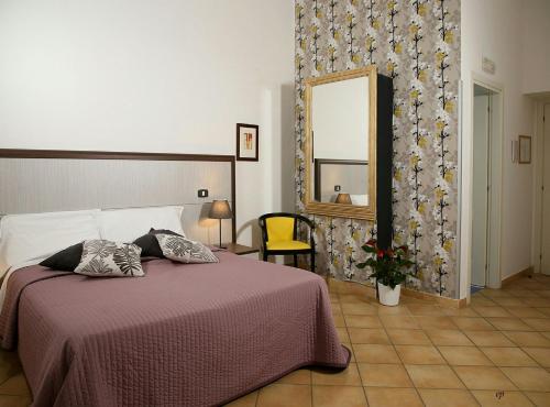 una camera con un letto e un grande specchio di Caravaggio Hotel a Napoli
