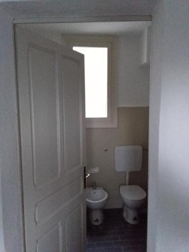 a bathroom with a toilet and a window at CASA VACANZE "LA QUIETE" in Nonio