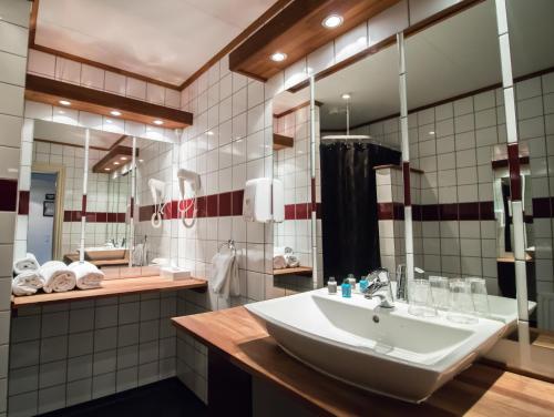 a bathroom with a sink and a large mirror at Hotel Phønix Hjørring in Hjørring