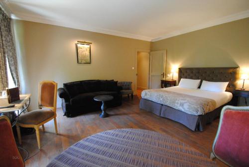 a bedroom with a bed and a desk and a chair at Hôtel Restaurant Spa Le Sauvage in Besançon