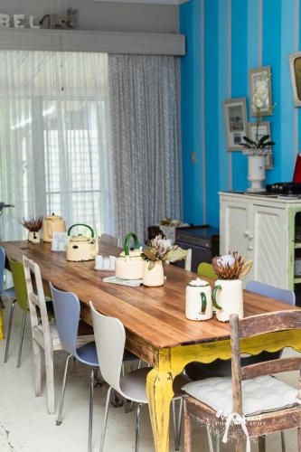 a wooden table with chairs around it in a room at Mirabel Guesthouse in Parys