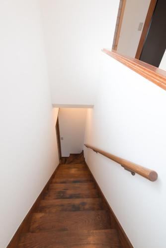 a hallway of a room with white walls and wooden floors at Suikomareso in Hita