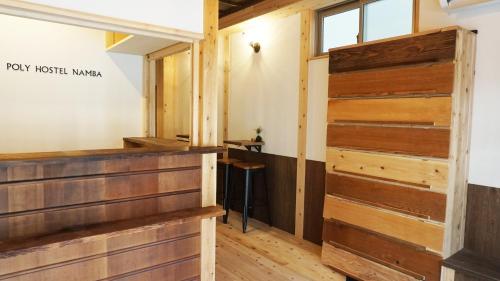 a wooden door in a room with wooden floors at Poly Hostel 2 Namba in Osaka